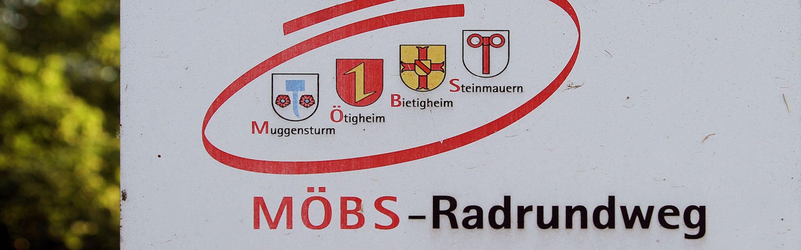 Schild vom MÖBS-Radweg mit den Wappen der vier Gemeinden und dem Titel "MÖBS-Radweg""