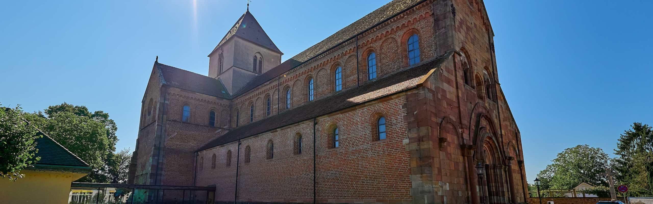 Schwarzacher Münster Das Bild zeigt eine Außenaufnahme eines Klosters vor blauen Himmel und Bäumen ringsum