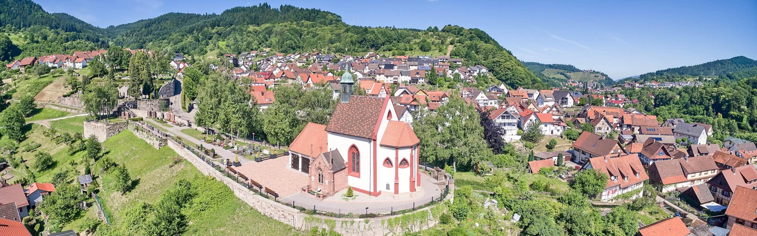 Das Bild zeigt eine Kirche und umliegende Häuser aus der Vogelperspektive